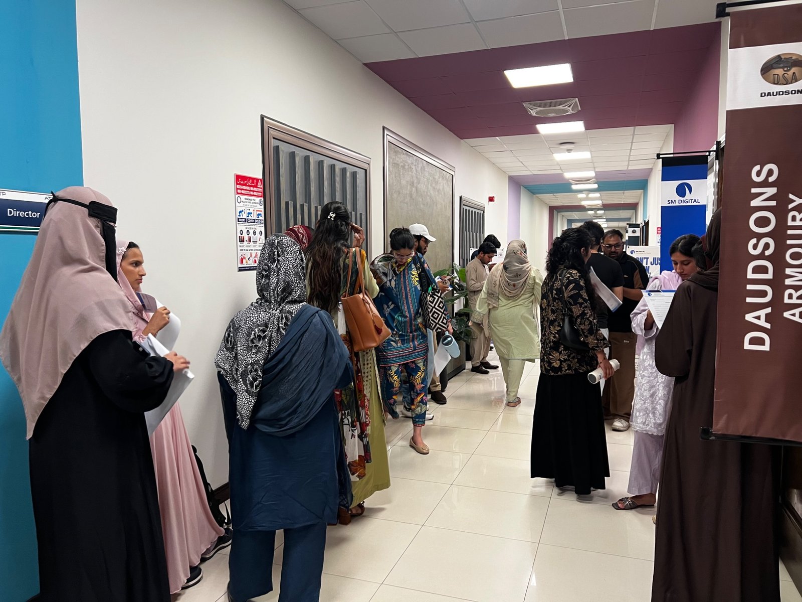Event participants gathered in the corridor beside an SM Digital banner
